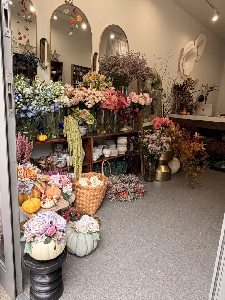 Wnętrze atelier Forma Botanica w Krakowie z regałami pełnymi kwiatów ciętych